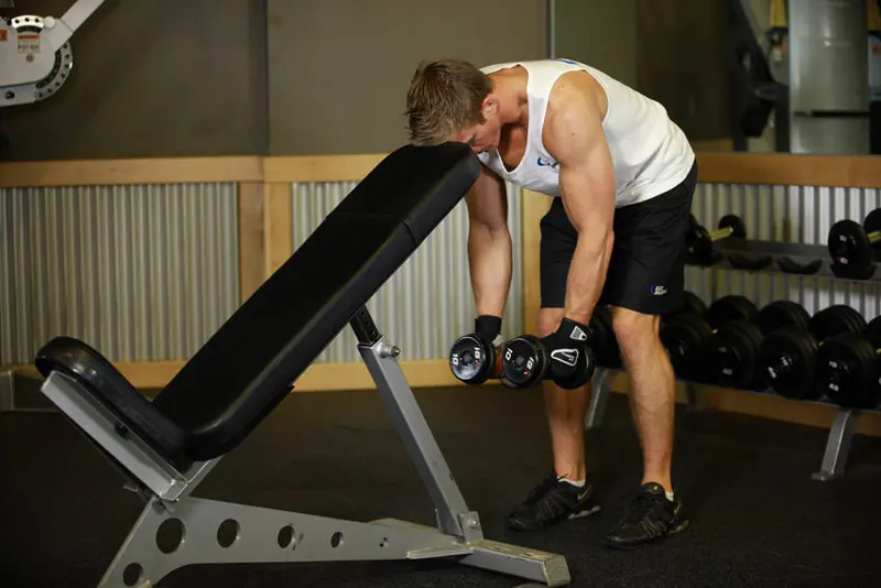 Bent Over Dumbbell Rear Delt Raise With Head On Bench: starting position